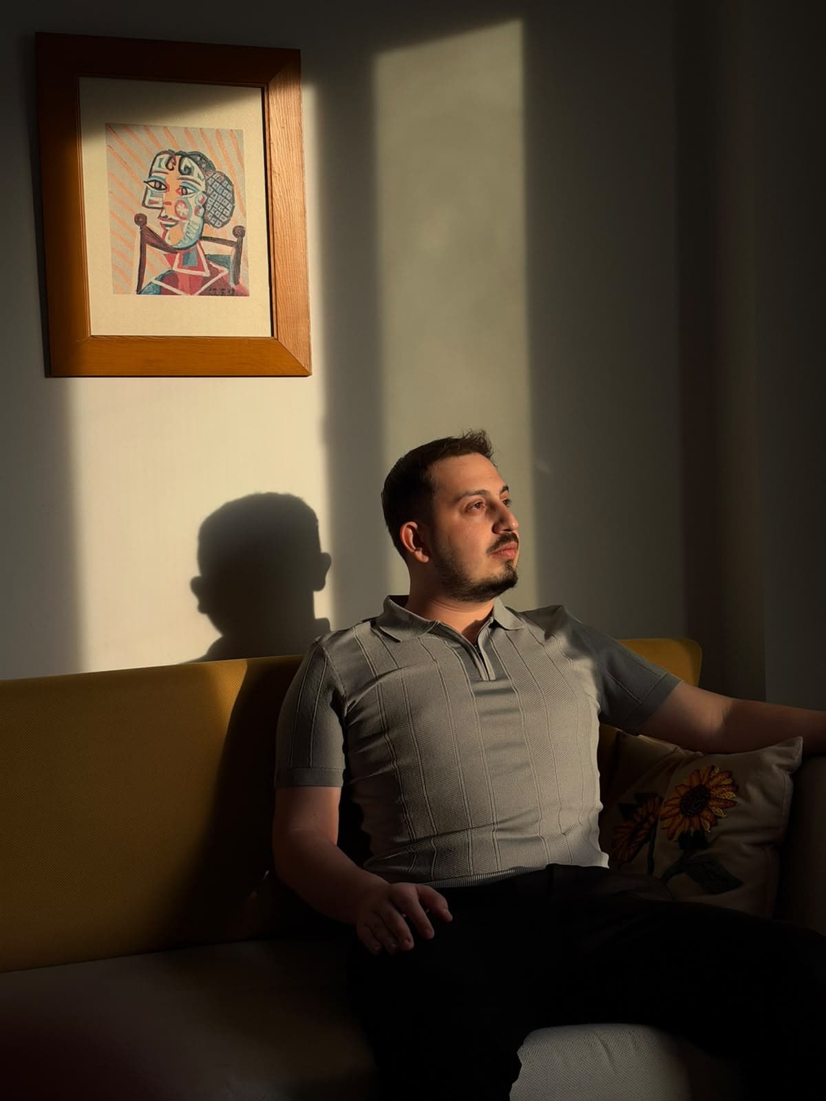 Psk. Murathan Alpman, ışık alan bir odada kanepede otururken